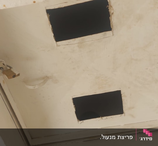 חלון חילוץ של מקלט עם מנעול תלייה מותקן